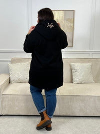 Découvrez notre manteau mi-long noir élégant et tendance, orné de détails léopards sur la capuche et les manches. Pratique et confortable, il dispose de deux poches à l’avant et de boutons sur toute la longueur. Avec sa capuche et son style raffiné, il allie chaleur, originalité et modernité pour un look unique en toute saison.