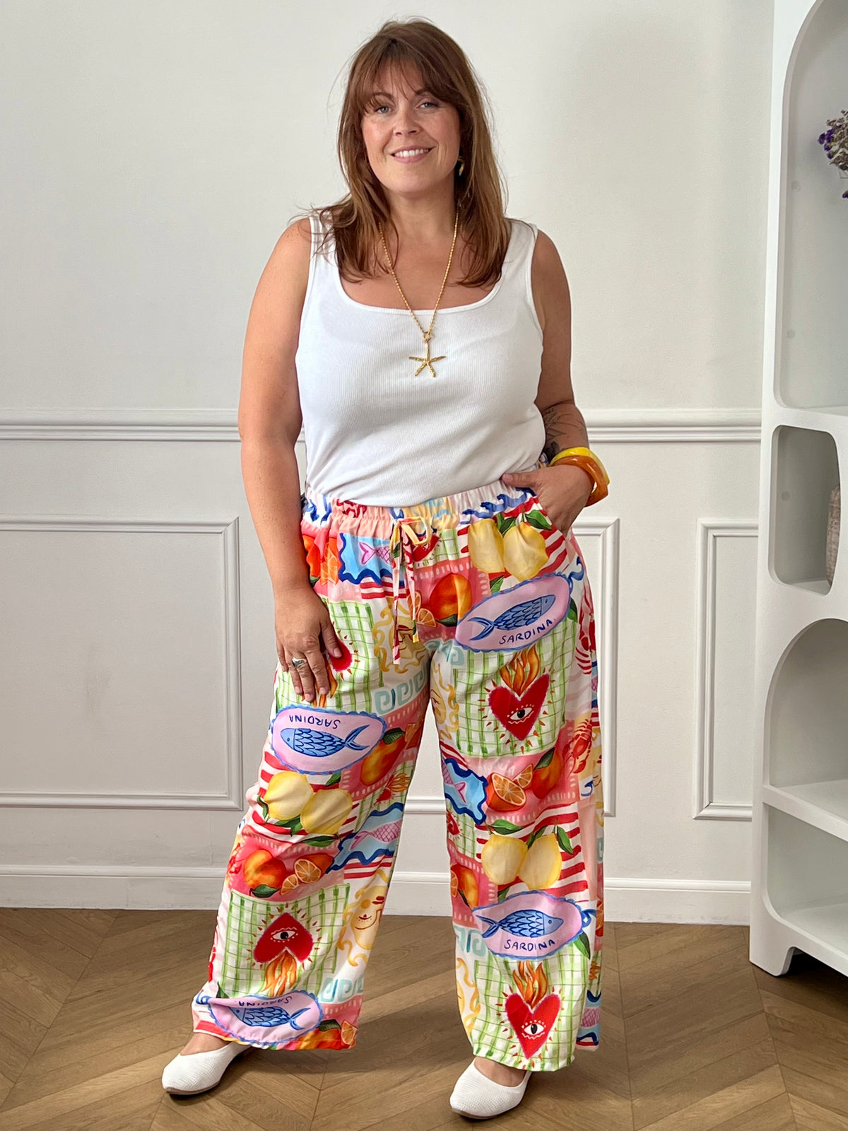 Craquez pour ce pantalon coloré grande taille femme, idéal pour apporter une touche de fraîcheur et d'originalité à vos tenues. Sa coupe droite et ample offre un confort optimal, tandis que sa taille élastiquée assure un ajustement parfait au quotidien. Doté de deux poches latérales pratiques et de liens factices à la taille, il se distingue par ses motifs colorés aux nuances de blanc, bleu, jaune, orange, vert et rose. Une pièce tendance et confortable, parfaite pour illuminer votre dressing.