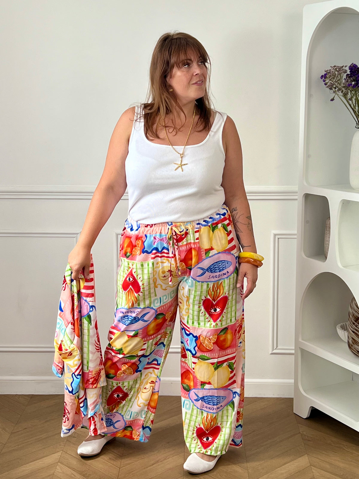 Craquez pour ce pantalon coloré grande taille femme, idéal pour apporter une touche de fraîcheur et d'originalité à vos tenues. Sa coupe droite et ample offre un confort optimal, tandis que sa taille élastiquée assure un ajustement parfait au quotidien. Doté de deux poches latérales pratiques et de liens factices à la taille, il se distingue par ses motifs colorés aux nuances de blanc, bleu, jaune, orange, vert et rose. Une pièce tendance et confortable, parfaite pour illuminer votre dressing.