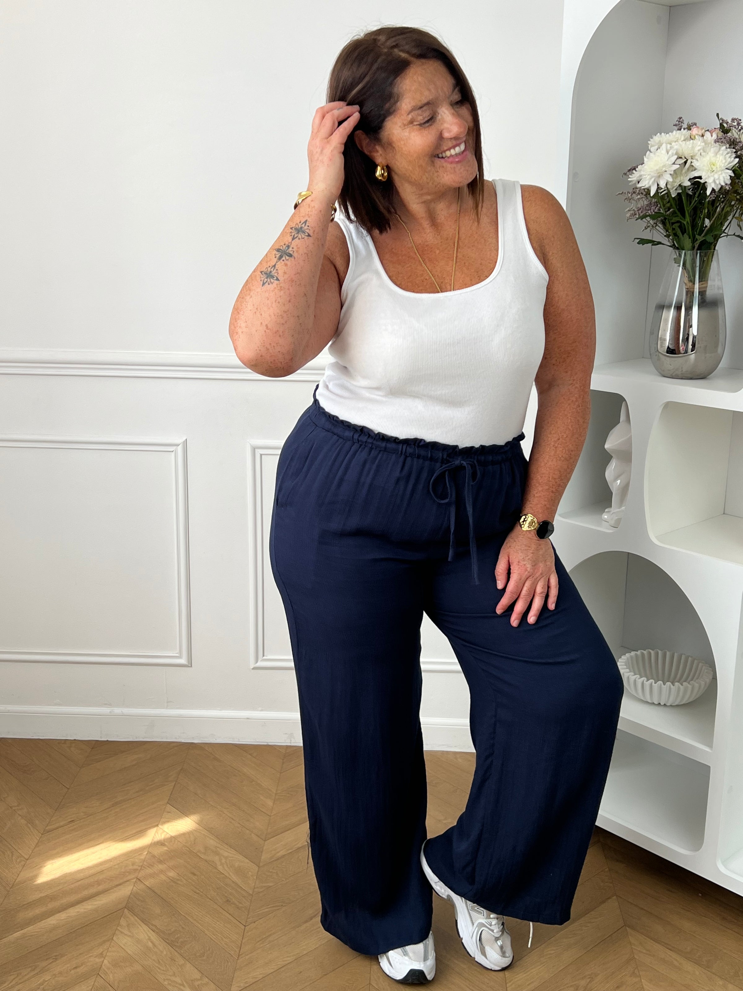 Optez pour ce pantalon élastique grande taille femme à coupe droite, alliant confort et style. Sa taille élastiquée avec lien à nouer assure un ajustement parfait. En bleu marine, il s’adapte facilement à toutes vos tenues du quotidien.