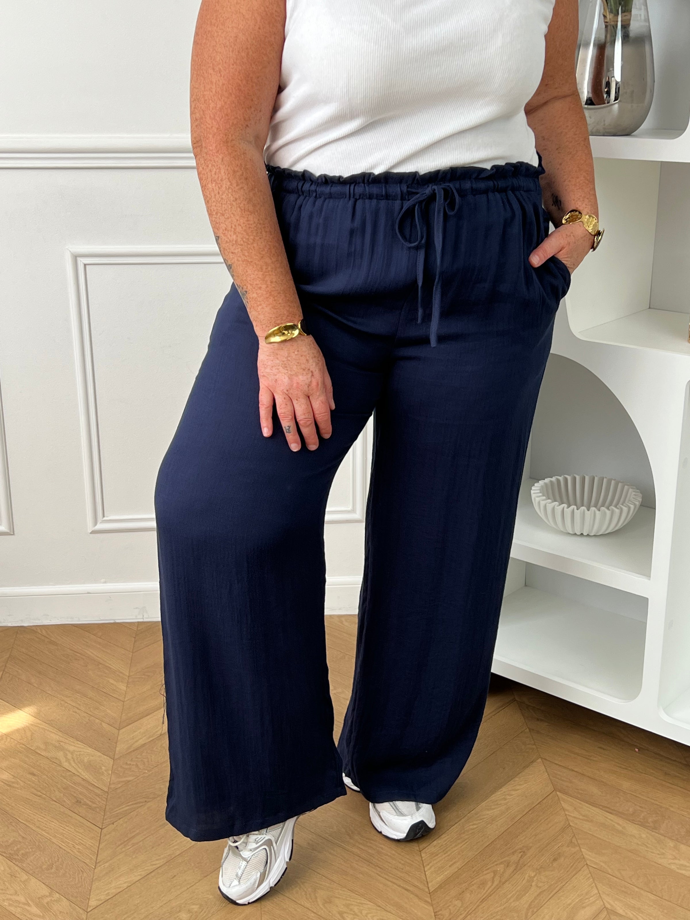 Optez pour ce pantalon élastique grande taille femme à coupe droite, alliant confort et style. Sa taille élastiquée avec lien à nouer assure un ajustement parfait. En bleu marine, il s’adapte facilement à toutes vos tenues du quotidien.