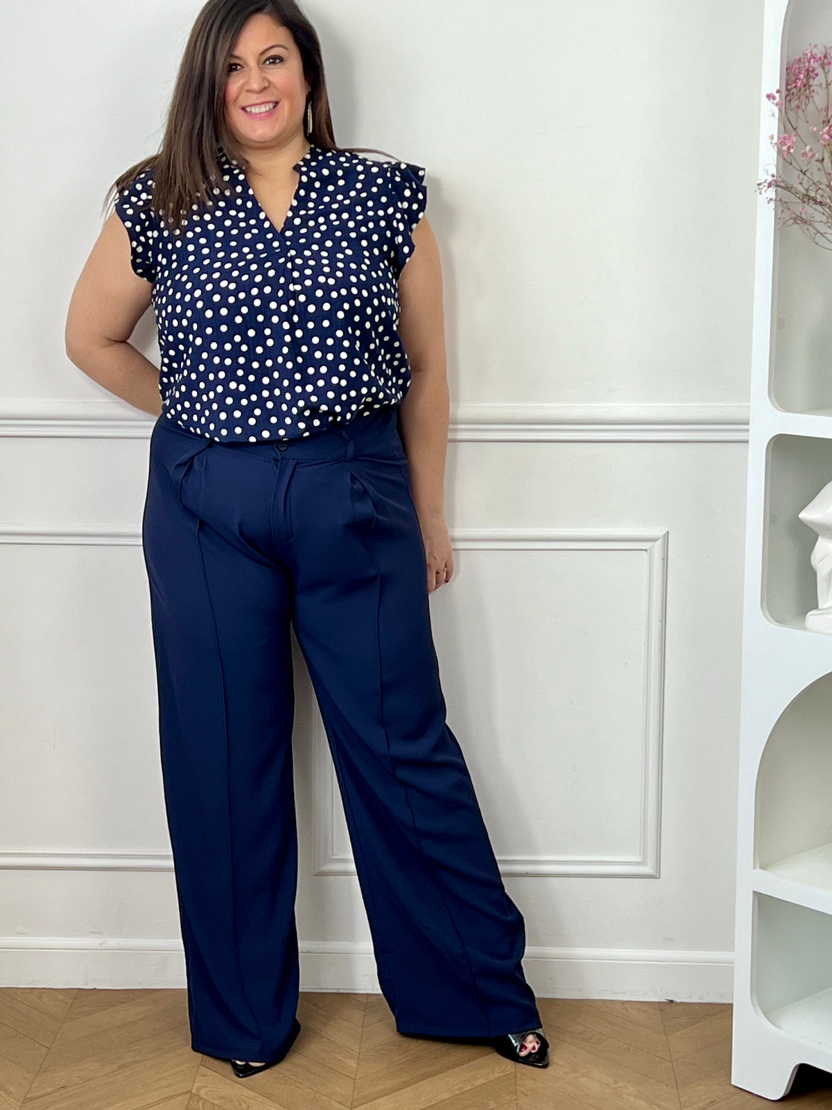 Pantalon grande taille femme à coupe droite, parfait pour une silhouette élégante et confortable. Doté de plis sur le devant et d’une taille élastique au dos, il assure un ajustement optimal tout en restant agréable à porter. Ses passants pour ceinture permettent de structurer la tenue selon vos envies. Confectionné dans une matière fluide, ce pantalon bleu marine est idéal pour un look chic et polyvalent au quotidien.