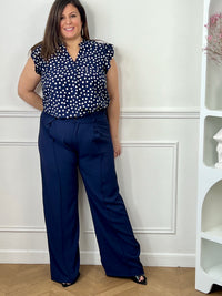 Pantalon grande taille femme à coupe droite, parfait pour une silhouette élégante et confortable. Doté de plis sur le devant et d’une taille élastique au dos, il assure un ajustement optimal tout en restant agréable à porter. Ses passants pour ceinture permettent de structurer la tenue selon vos envies. Confectionné dans une matière fluide, ce pantalon bleu marine est idéal pour un look chic et polyvalent au quotidien.