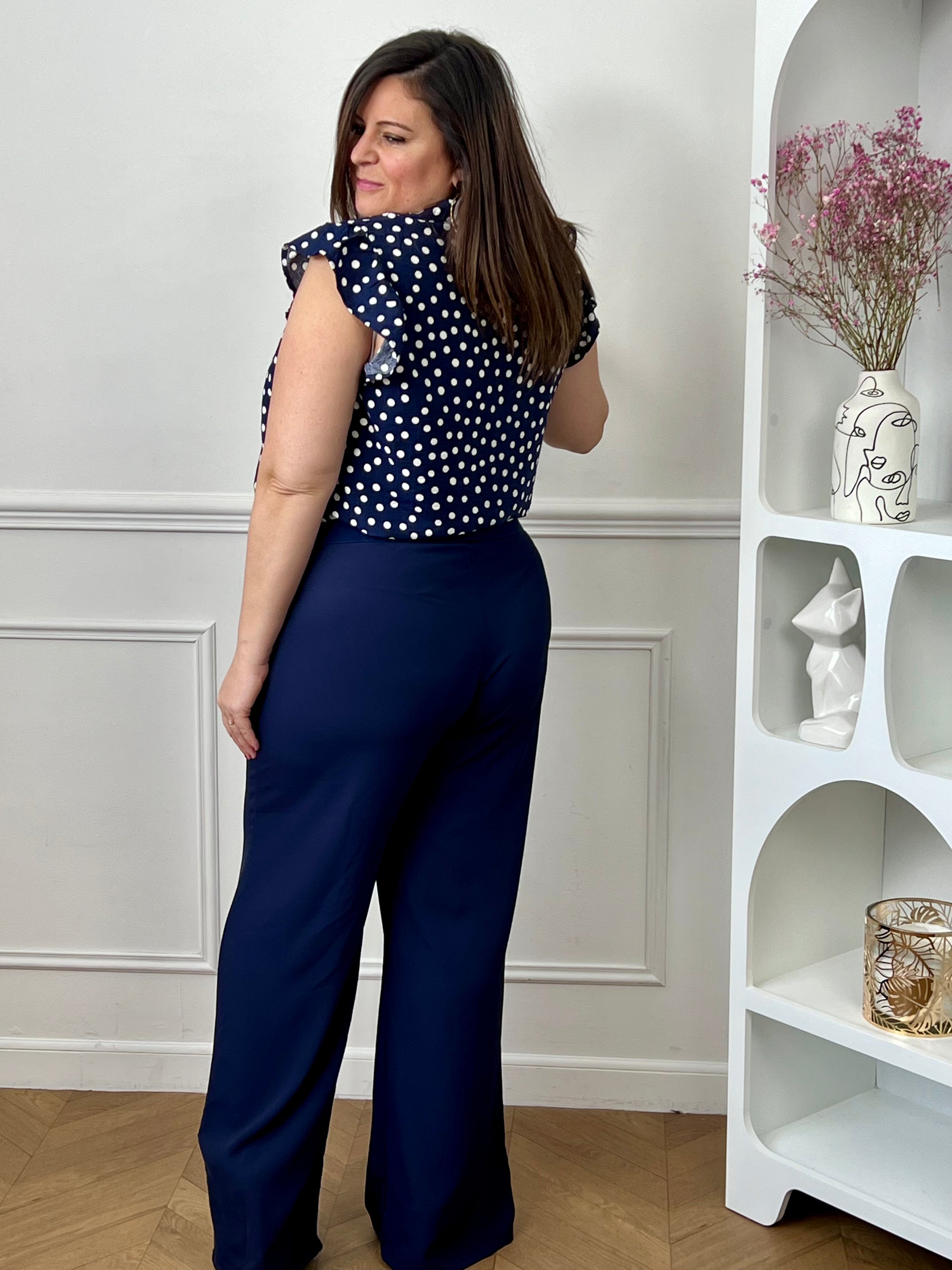Pantalon grande taille femme à coupe droite, parfait pour une silhouette élégante et confortable. Doté de plis sur le devant et d’une taille élastique au dos, il assure un ajustement optimal tout en restant agréable à porter. Ses passants pour ceinture permettent de structurer la tenue selon vos envies. Confectionné dans une matière fluide, ce pantalon bleu marine est idéal pour un look chic et polyvalent au quotidien.