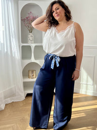 Découvrez le confort ultime avec ce pantalon fluide grande taille Paola. Confectionné dans une matière douce et aérienne, il épouse vos formes sans contrainte grâce à son coupe ample et son élastique discret au dos. Les poches latérales avant offrent praticité et style, tandis que la ceinture amovible à motifs vous permet de personnaliser votre look selon vos envies.