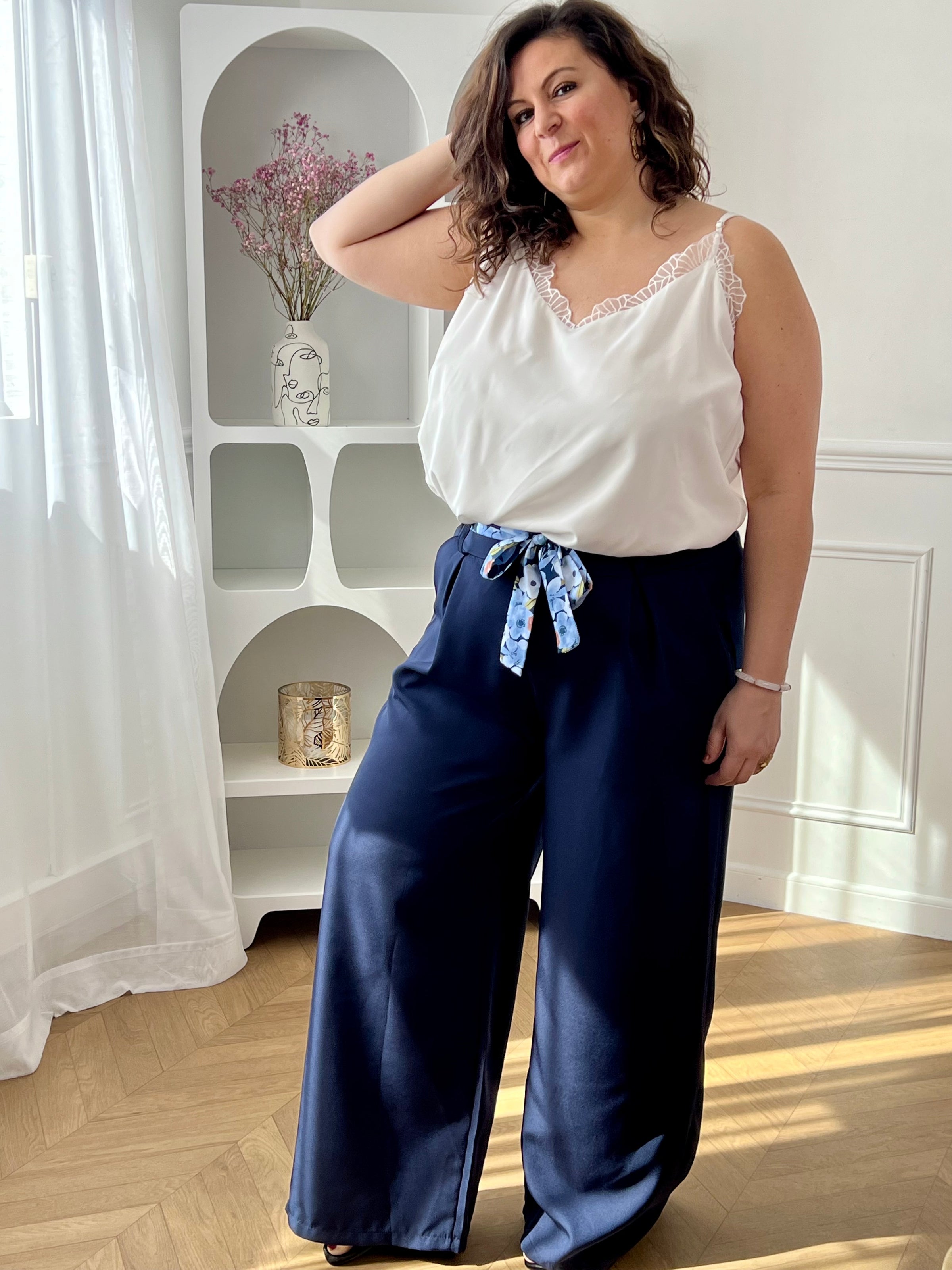 Découvrez le confort ultime avec ce pantalon fluide grande taille Paola. Confectionné dans une matière douce et aérienne, il épouse vos formes sans contrainte grâce à son coupe ample et son élastique discret au dos. Les poches latérales avant offrent praticité et style, tandis que la ceinture amovible à motifs vous permet de personnaliser votre look selon vos envies.