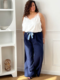 Découvrez le confort ultime avec ce pantalon fluide grande taille Paola. Confectionné dans une matière douce et aérienne, il épouse vos formes sans contrainte grâce à son coupe ample et son élastique discret au dos. Les poches latérales avant offrent praticité et style, tandis que la ceinture amovible à motifs vous permet de personnaliser votre look selon vos envies.