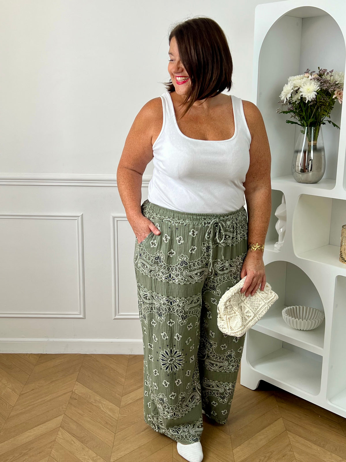 Pantalon kaki en gaze de coton grande taille femme, idéal pour un look confortable et tendance. Doté d’une taille élastique avec cordons factices et de deux poches latérales à l’avant, il offre une coupe ample agréable à porter au quotidien. Ses motifs bleus, noirs et écrus apportent une touche originale et moderne. Léger et fluide, ce pantalon kaki est parfait pour une tenue décontractée et stylée.