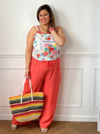 Apportez une touche de fraîcheur à votre dressing avec ce pantalon en lin grande taille femme. Sa taille élastiquée assure un confort optimal au quotidien, tandis que les liens factices ajoutent une finition élégante et décontractée. Doté de deux poches latérales pratiques à l’avant, ce modèle légèrement transparent séduit par sa matière légère et respirante. Sa couleur corail lumineuse en fait une pièce idéale pour composer des looks estivaux à la fois confortables et tendance.