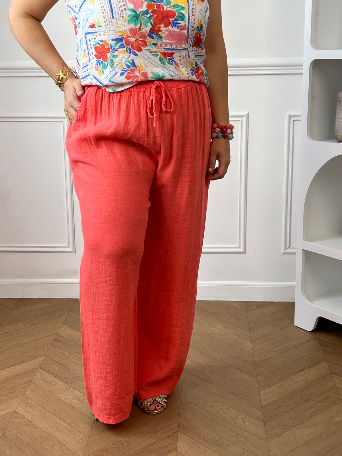 Apportez une touche de fraîcheur à votre dressing avec ce pantalon en lin grande taille femme. Sa taille élastiquée assure un confort optimal au quotidien, tandis que les liens factices ajoutent une finition élégante et décontractée. Doté de deux poches latérales pratiques à l’avant, ce modèle légèrement transparent séduit par sa matière légère et respirante. Sa couleur corail lumineuse en fait une pièce idéale pour composer des looks estivaux à la fois confortables et tendance.