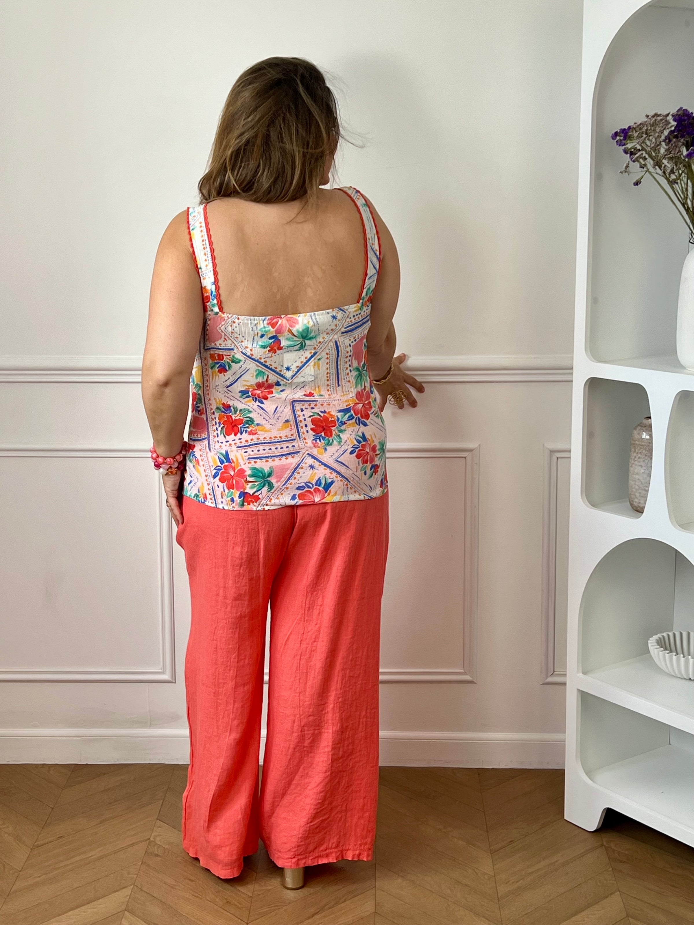 Apportez une touche de fraîcheur à votre dressing avec ce pantalon en lin grande taille femme. Sa taille élastiquée assure un confort optimal au quotidien, tandis que les liens factices ajoutent une finition élégante et décontractée. Doté de deux poches latérales pratiques à l’avant, ce modèle légèrement transparent séduit par sa matière légère et respirante. Sa couleur corail lumineuse en fait une pièce idéale pour composer des looks estivaux à la fois confortables et tendance.