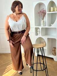Ce pantalon marron coupe droite grande taille pour femme est l'élégance incarnée. Avec sa matière fluide, il offre un confort optimal et sa coupe droite flatteuse convient à toutes les morphologies. L'élastique au dos garantit un ajustement parfait et les passants pour ceinture sont pratiques. Ajoutez-y un style sophistiqué avec ses deux poches latérales.