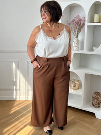 Ce pantalon marron coupe droite grande taille pour femme est l'élégance incarnée. Avec sa matière fluide, il offre un confort optimal et sa coupe droite flatteuse convient à toutes les morphologies. L'élastique au dos garantit un ajustement parfait et les passants pour ceinture sont pratiques. Ajoutez-y un style sophistiqué avec ses deux poches latérales.