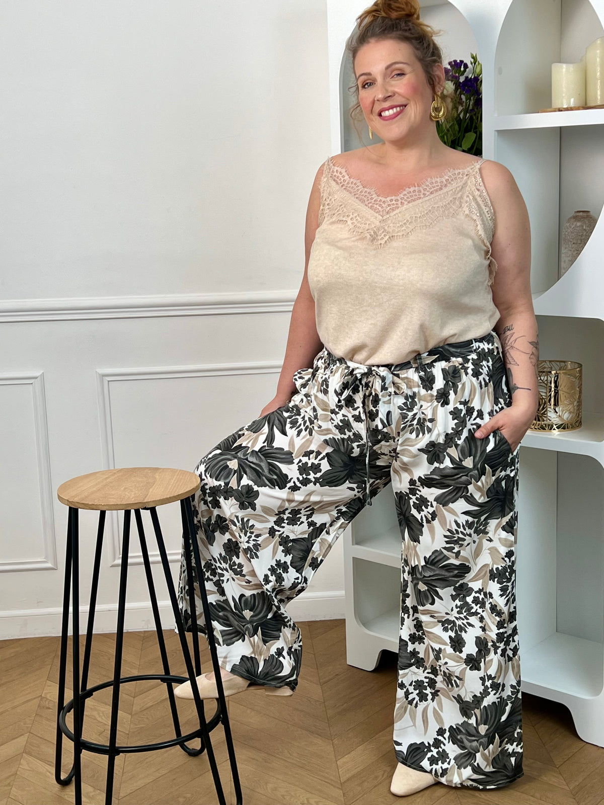 Pantalon à motifs grande taille femme, fluide et confortable, idéal pour un look tendance au quotidien. Doté d’une taille élastique, de poches latérales et de passants avec ceinture amovible, il s’adapte parfaitement à la silhouette. Ses motifs fleuris aux nuances noir, gris, taupe et écru apportent une touche élégante et féminine. Ce pantalon fluide est parfait pour une tenue chic et décontractée.