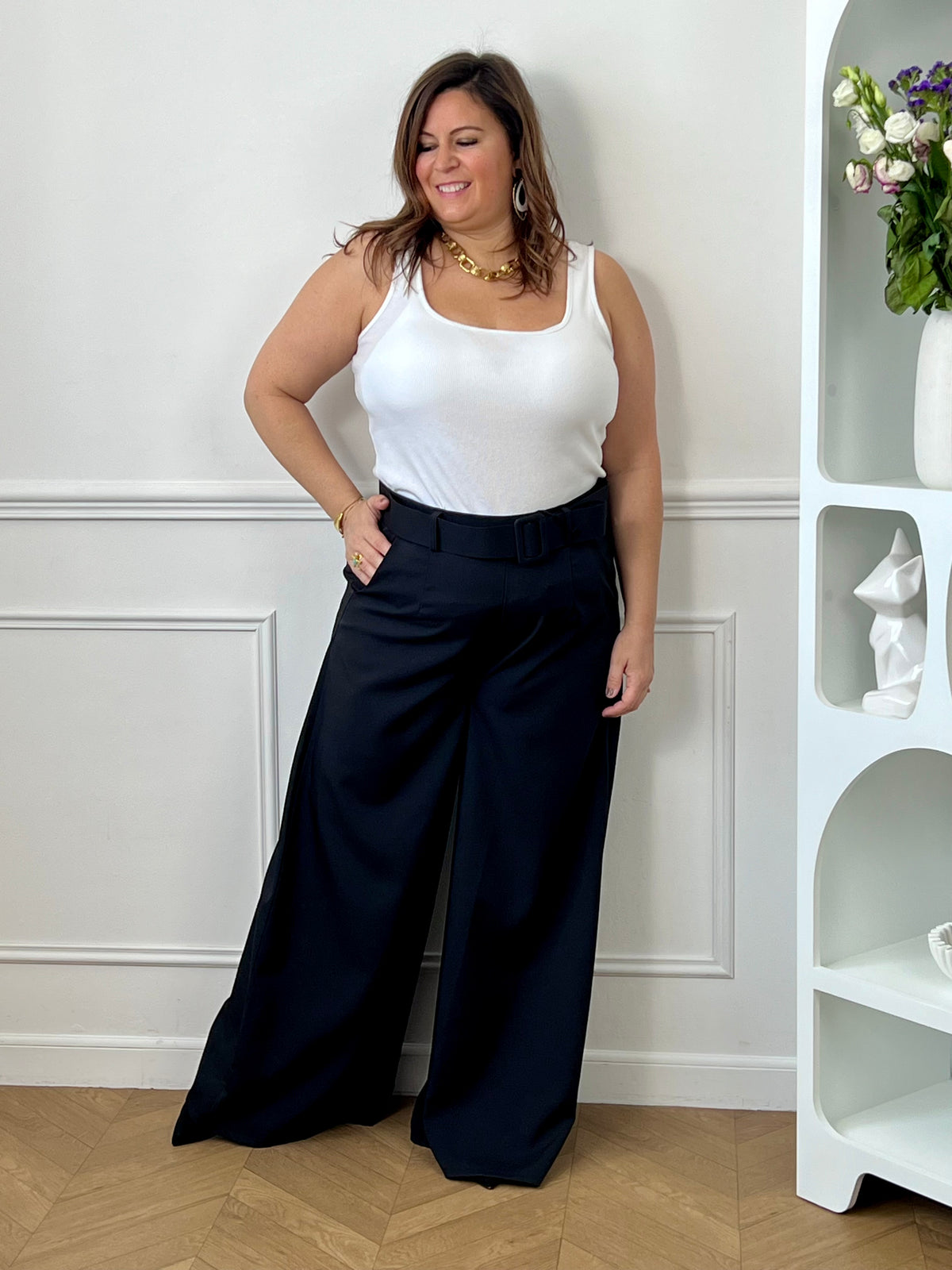 Élégant et intemporel, ce pantalon ample noir séduit par sa coupe fluide et sa ceinture assortie. Une pièce chic et polyvalente, parfaite pour composer des looks raffinés au quotidien.
