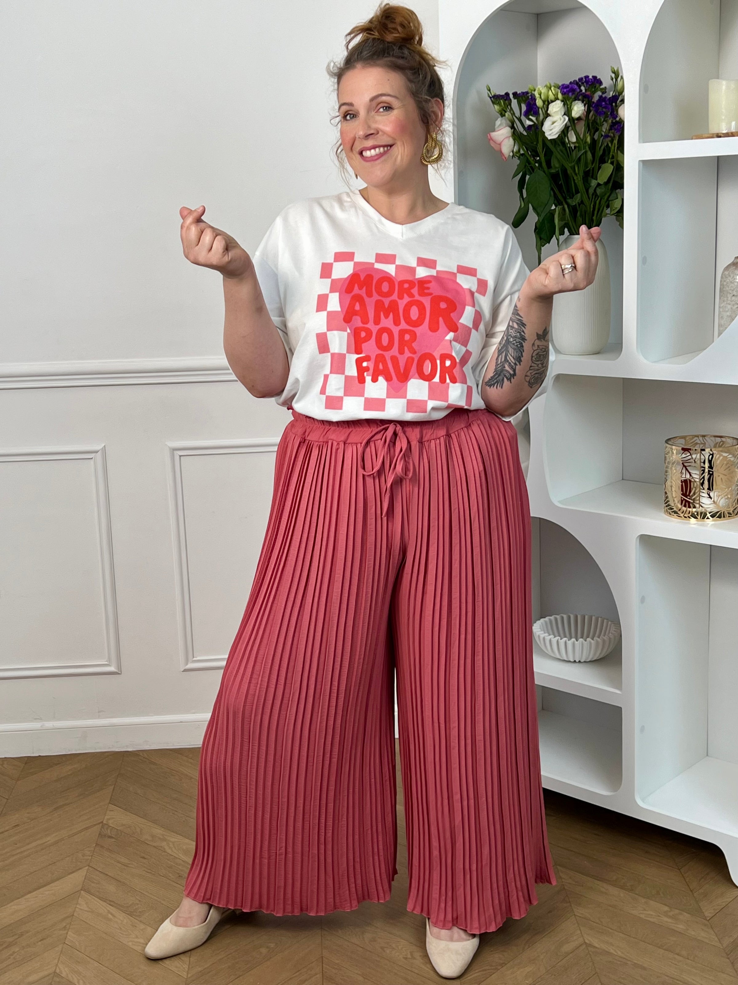 Pantalon Loresa au design élégant et confortable. Sa couleur rose tendance s'accompagne de plis raffinés qui apportent du mouvement à votre silhouette. La taille élastique avec lien de serrage réglable assure un confort optimal tout au long de la journée.