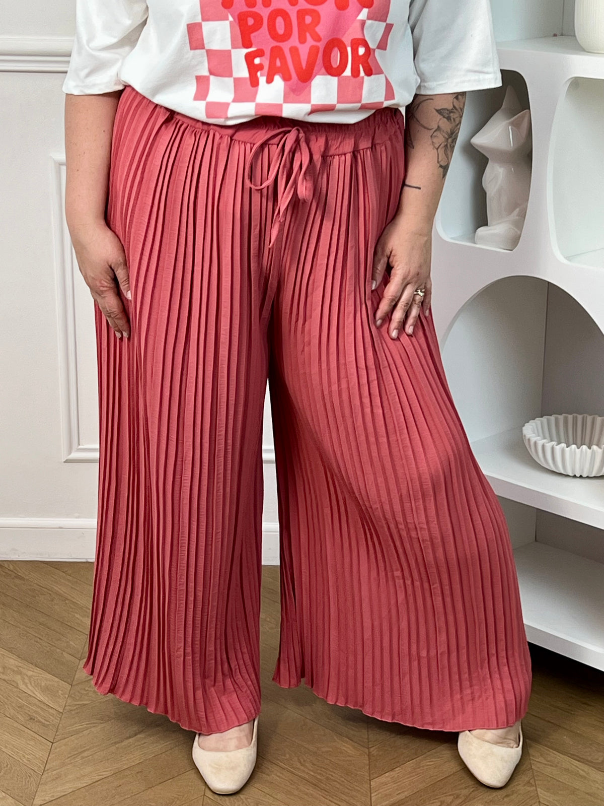 Pantalon Loresa au design élégant et confortable. Sa couleur rose tendance s'accompagne de plis raffinés qui apportent du mouvement à votre silhouette. La taille élastique avec lien de serrage réglable assure un confort optimal tout au long de la journée.