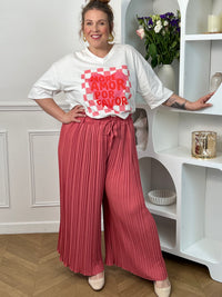 Pantalon Loresa au design élégant et confortable. Sa couleur rose tendance s'accompagne de plis raffinés qui apportent du mouvement à votre silhouette. La taille élastique avec lien de serrage réglable assure un confort optimal tout au long de la journée.