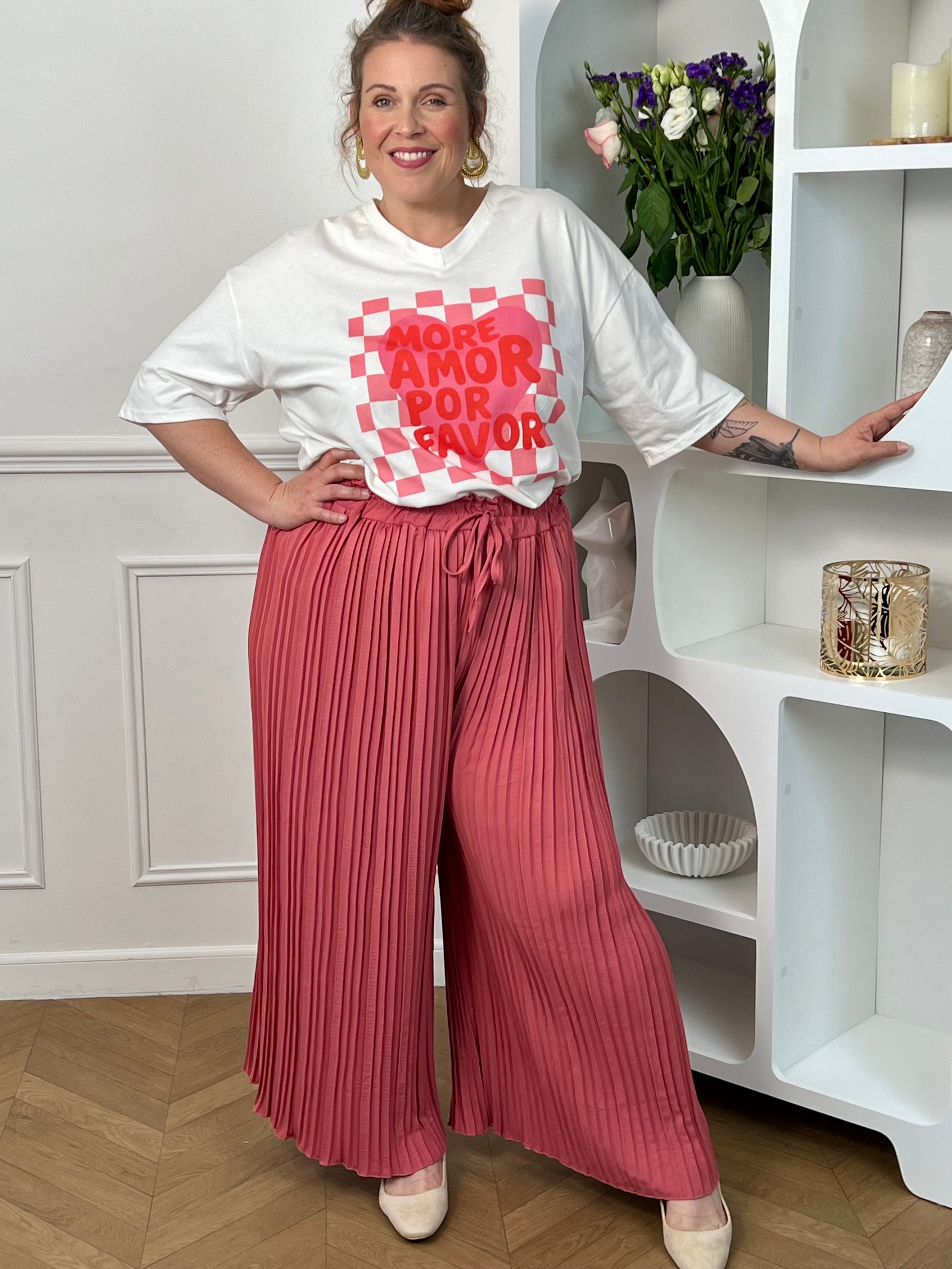 Pantalon Loresa au design élégant et confortable. Sa couleur rose tendance s'accompagne de plis raffinés qui apportent du mouvement à votre silhouette. La taille élastique avec lien de serrage réglable assure un confort optimal tout au long de la journée.