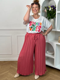 Pantalon Loresa au design élégant et confortable. Sa couleur rose tendance s'accompagne de plis raffinés qui apportent du mouvement à votre silhouette. La taille élastique avec lien de serrage réglable assure un confort optimal tout au long de la journée.
