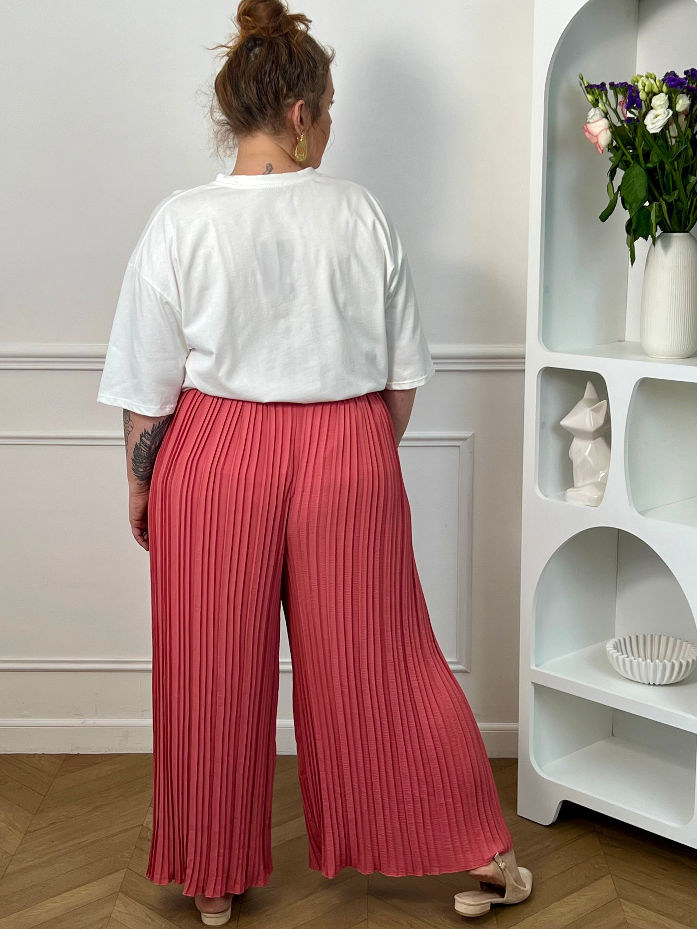 Pantalon Loresa au design élégant et confortable. Sa couleur rose tendance s'accompagne de plis raffinés qui apportent du mouvement à votre silhouette. La taille élastique avec lien de serrage réglable assure un confort optimal tout au long de la journée.