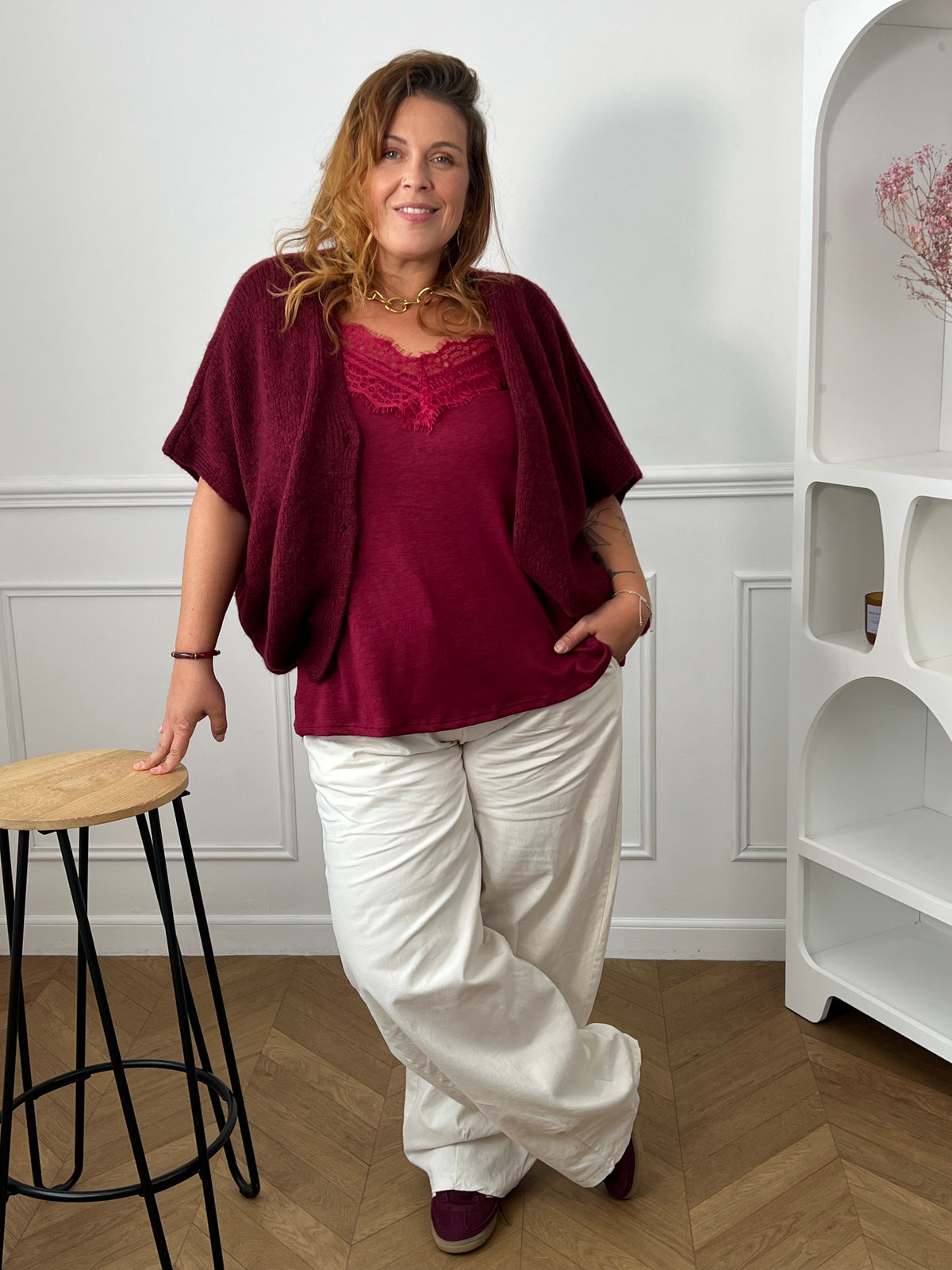 Pantalon Tall écru grande taille porté jambes croisées avec un top et un gilet bordeaux – Emine | Loïcia