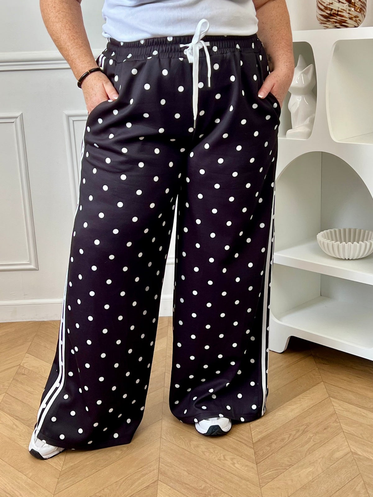 Adoptez ce pantalon noir à pois écrus au style jogging revisité. Sa taille élastique assure un maintien parfait tout en offrant une silhouette actuelle et décontractée.