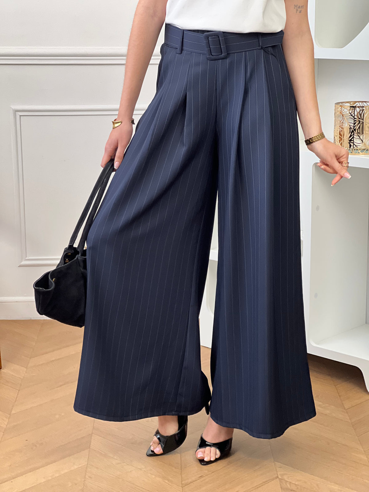 Élégant et intemporel, ce pantalon ample bleu marine à rayures séduit par sa coupe fluide et sa ceinture assortie. Une pièce chic et polyvalente, parfaite pour composer des looks raffinés au quotidien.