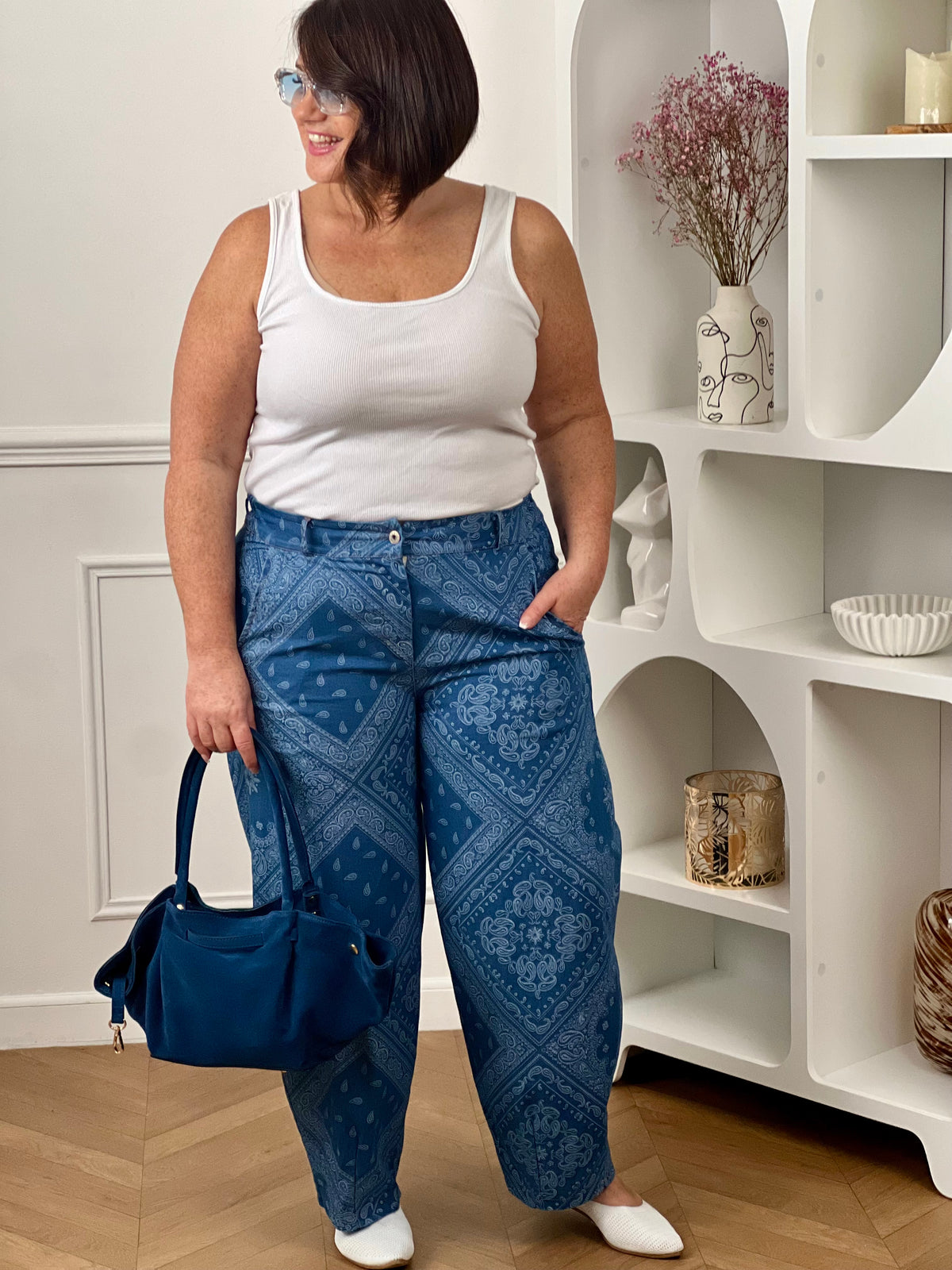 Pantalon bleu à motif bandana grande taille, au style tendance et original. Sa coupe ballon moderne associée à un élastique au dos de la taille et des passants pour ceinture assure un confort optimal et un ajustement parfait. Doté de poches latérales pratiques, il allie style et fonctionnalité. Ses motifs bandana blancs sur fond bleu apportent une touche unique à vos tenues.
