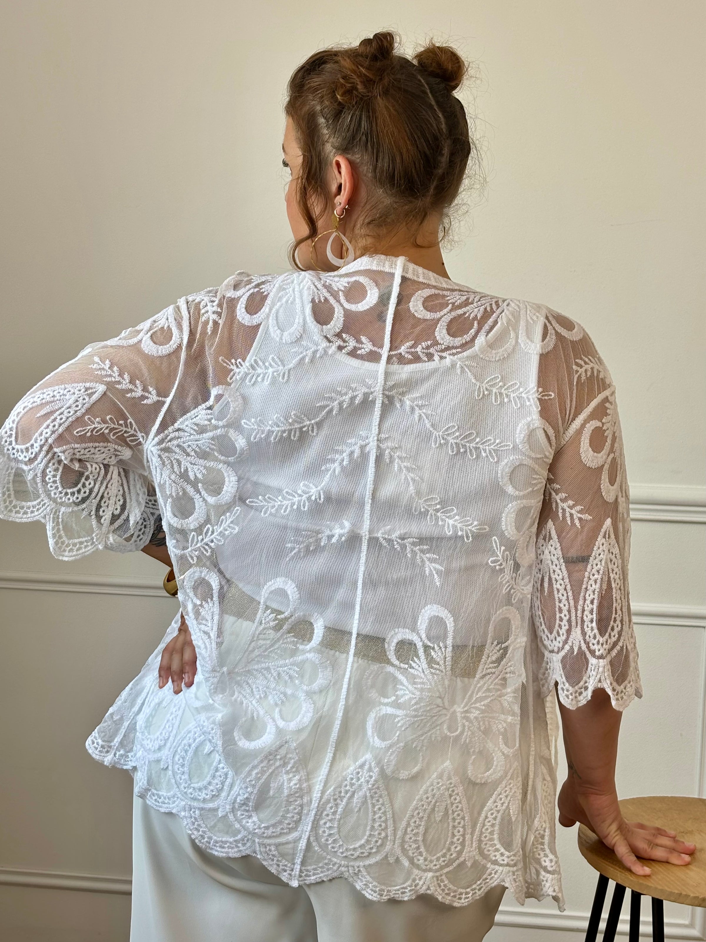 Complétez votre tenue de plage avec ce paréo court blanc grande taille. Léger et ajouré, il est sublimé par de jolis motifs brodés et se noue facilement sur le devant grâce à son lien. Confectionné en coton et polyester, il est idéal à enfiler par-dessus votre maillot de bain.