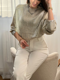 Élégant et moderne, ce pull beige s’illumine de détails argentés brillants sur l’ensemble du tissu. Une pièce chic et tendance, parfaite pour apporter une touche d’éclat à ton look.