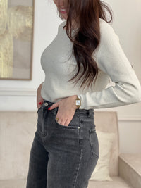 Le pull Celestina combine élégance et sensualité avec son dos nu en V à lien noué et ses manches longues. Orné de fil lurex doré, ce pull beige et doré brille de mille feux. Son col rond festonné ajoute une touche de raffinement pour des occasions spéciales.