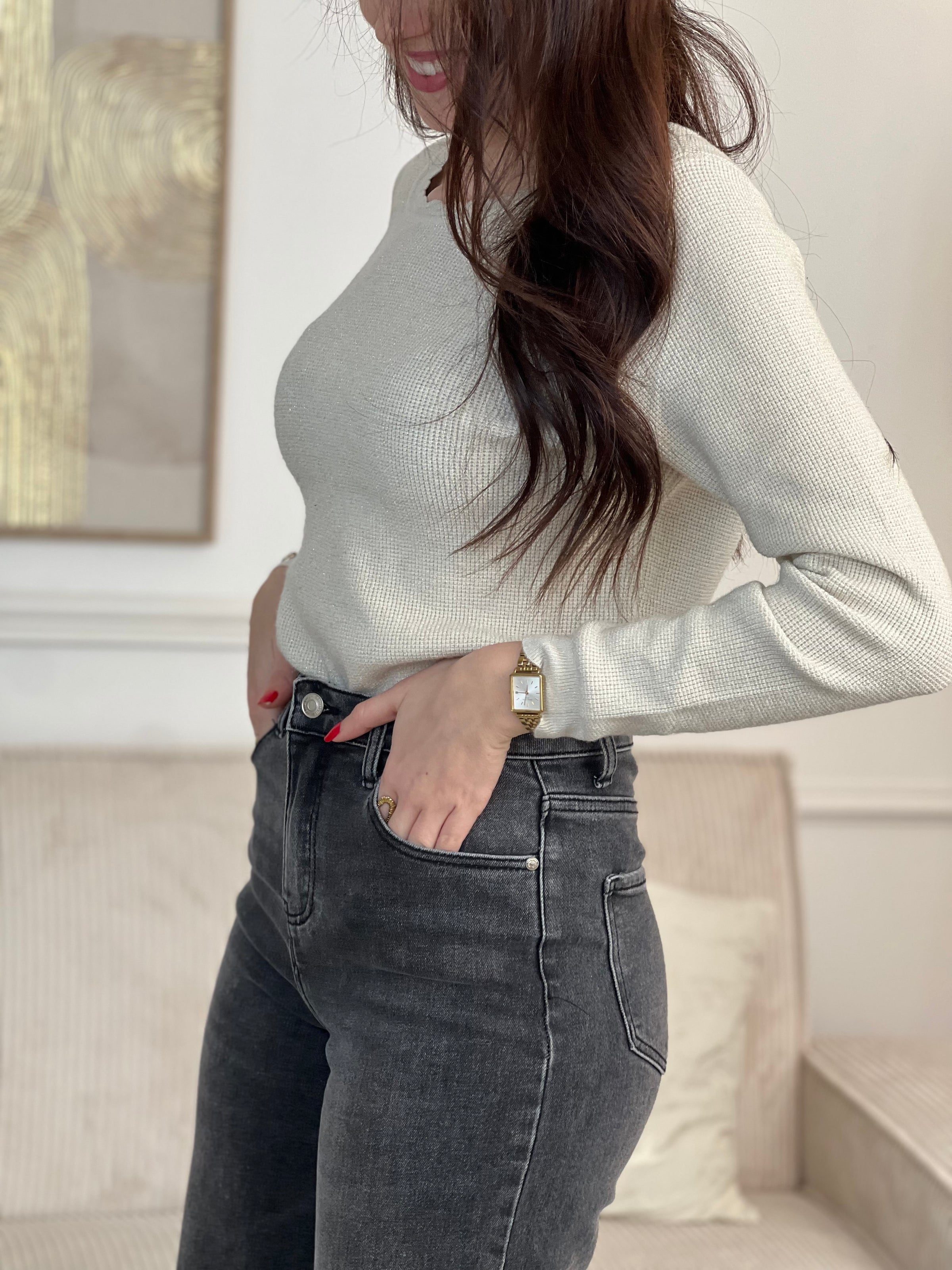 Le pull Celestina combine élégance et sensualité avec son dos nu en V à lien noué et ses manches longues. Orné de fil lurex doré, ce pull beige et doré brille de mille feux. Son col rond festonné ajoute une touche de raffinement pour des occasions spéciales.