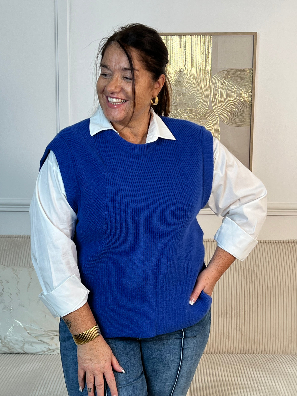 Ophelia, le pull sans manches bleu roi pour femme grande taille qui transforme votre garde-robe. Son col rond épuré et ses boutons marrons latéraux lui confèrent une touche de caractère. Versatile et incontournable, portez-le seul pour un look minimaliste ou superposez-le sur une chemise ou un top pour créer des combinaisons sans fin.