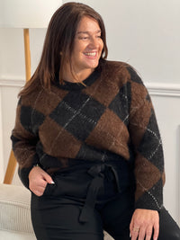 Pull femme Aveline aux motifs losanges géométriques. Manches longues et col rond pour un style intemporel. Teintes harmonieuses de marron, écru et gris foncé qui s'associent facilement à vos tenues du quotidien.