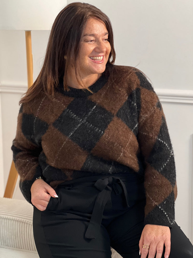 Pull femme Aveline aux motifs losanges géométriques. Manches longues et col rond pour un style intemporel. Teintes harmonieuses de marron, écru et gris foncé qui s'associent facilement à vos tenues du quotidien.
