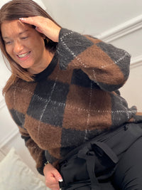 Pull femme Aveline aux motifs losanges géométriques. Manches longues et col rond pour un style intemporel. Teintes harmonieuses de marron, écru et gris foncé qui s'associent facilement à vos tenues du quotidien.