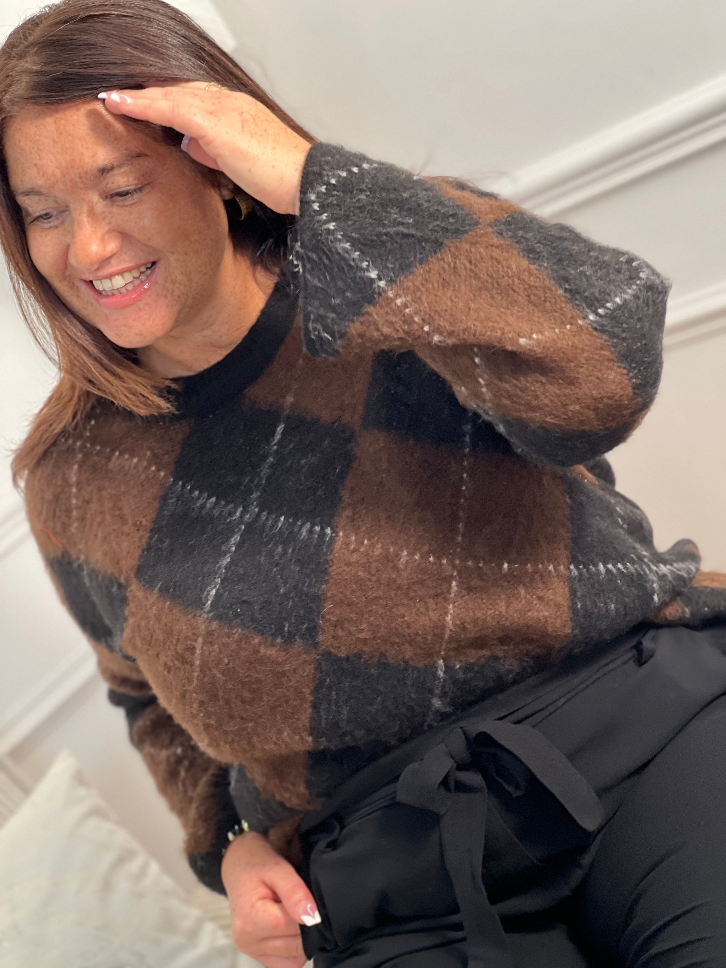 Pull femme Aveline aux motifs losanges géométriques. Manches longues et col rond pour un style intemporel. Teintes harmonieuses de marron, écru et gris foncé qui s'associent facilement à vos tenues du quotidien.