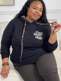 Rejoignez le "Cool mom club" avec notre pull noir à capuche Naelya. Les cordons léopards apportent une touche de style, tandis que l'intérieur léopard de la capuche vous garde au chaud. Les manches longues vous offrent confort et praticité.