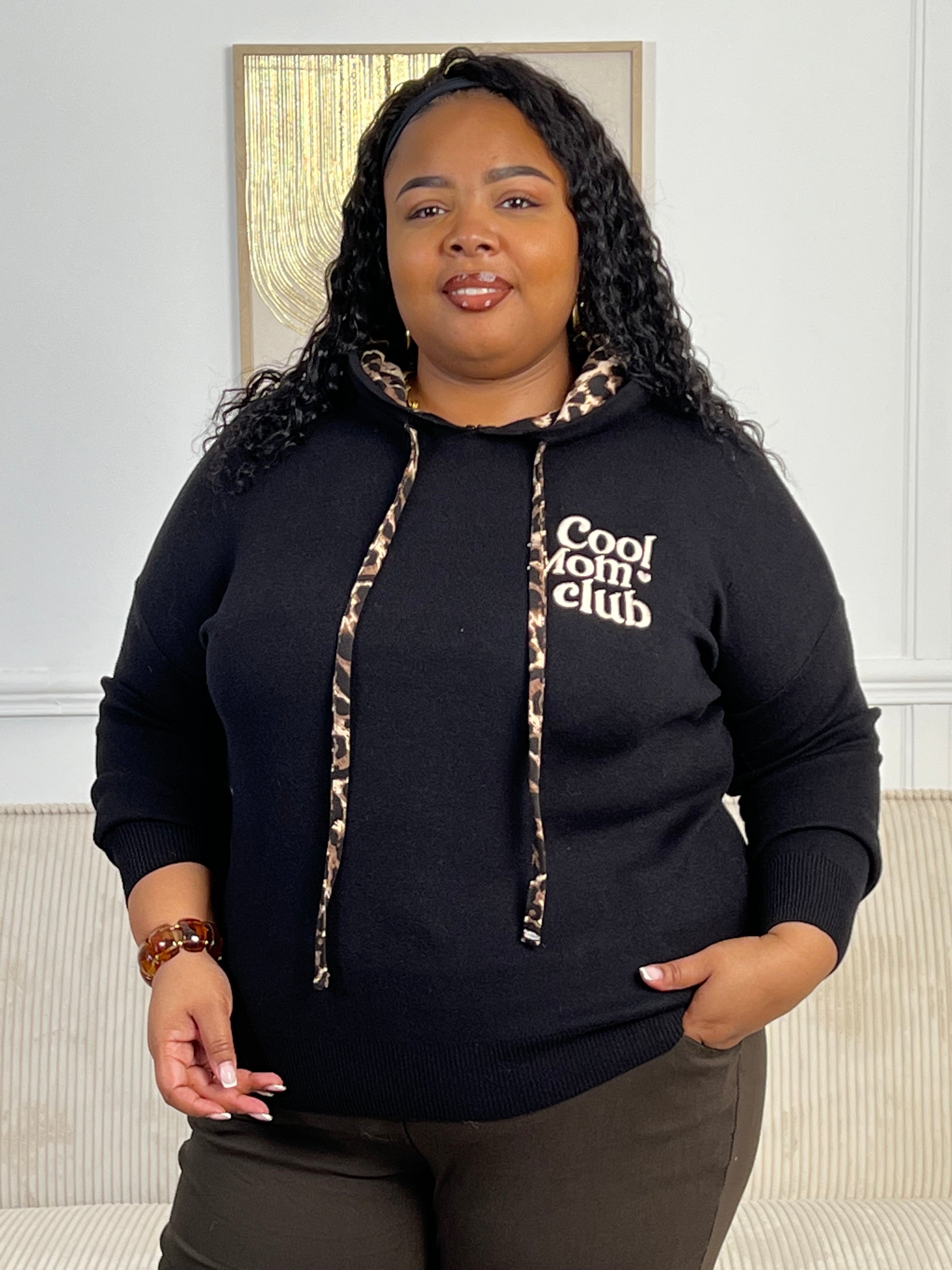 Rejoignez le "Cool mom club" avec notre pull noir à capuche Naelya. Les cordons léopards apportent une touche de style, tandis que l'intérieur léopard de la capuche vous garde au chaud. Les manches longues vous offrent confort et praticité.