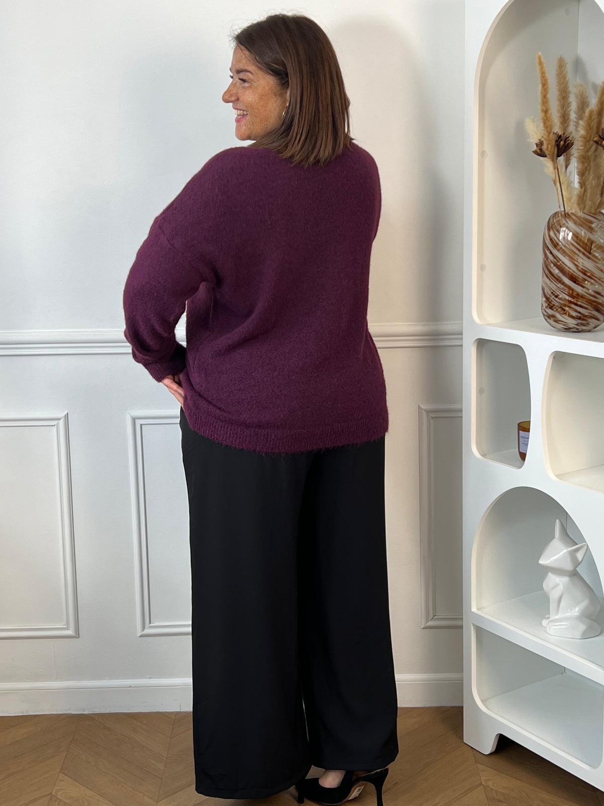 Pull violet grande taille vu de trois quarts dos, montrant sa coupe ample et sa finition côtelée sur les hanches – Daisie | Loïcia