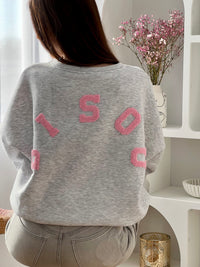 Adoptez ce sweat gris femme à la coupe large, confortable et tendance. Doté d’un col rond et de manches longues, il se distingue par son inscription “Bisou” en rose au dos qui apporte une touche originale. Un sweat gris et rose parfait pour un look casual et moderne.