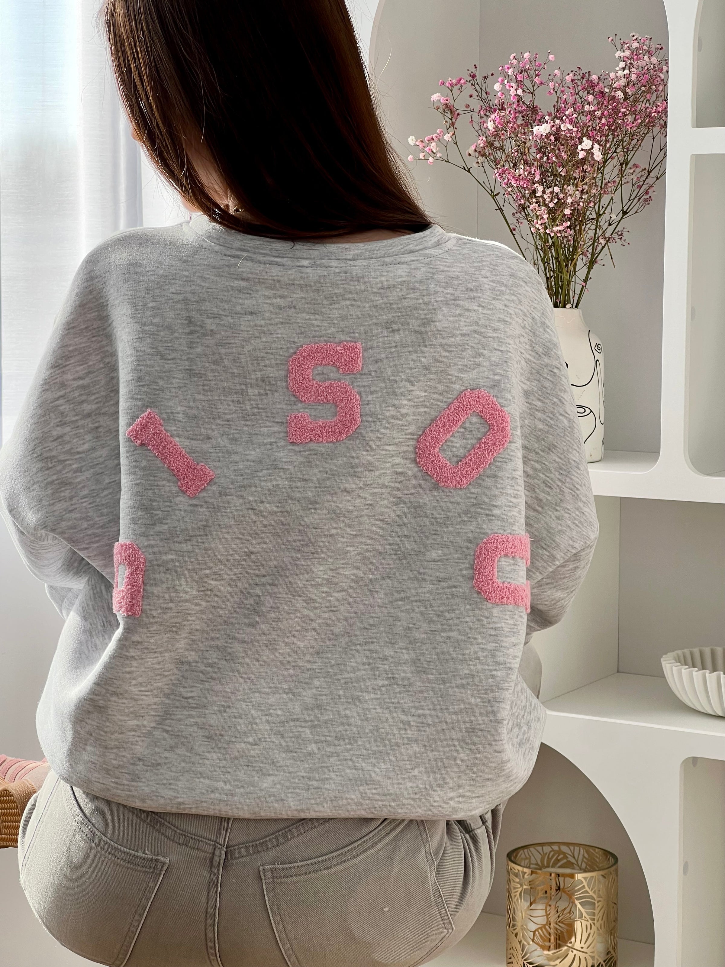 Adoptez ce sweat gris femme à la coupe large, confortable et tendance. Doté d’un col rond et de manches longues, il se distingue par son inscription “Bisou” en rose au dos qui apporte une touche originale. Un sweat gris et rose parfait pour un look casual et moderne.