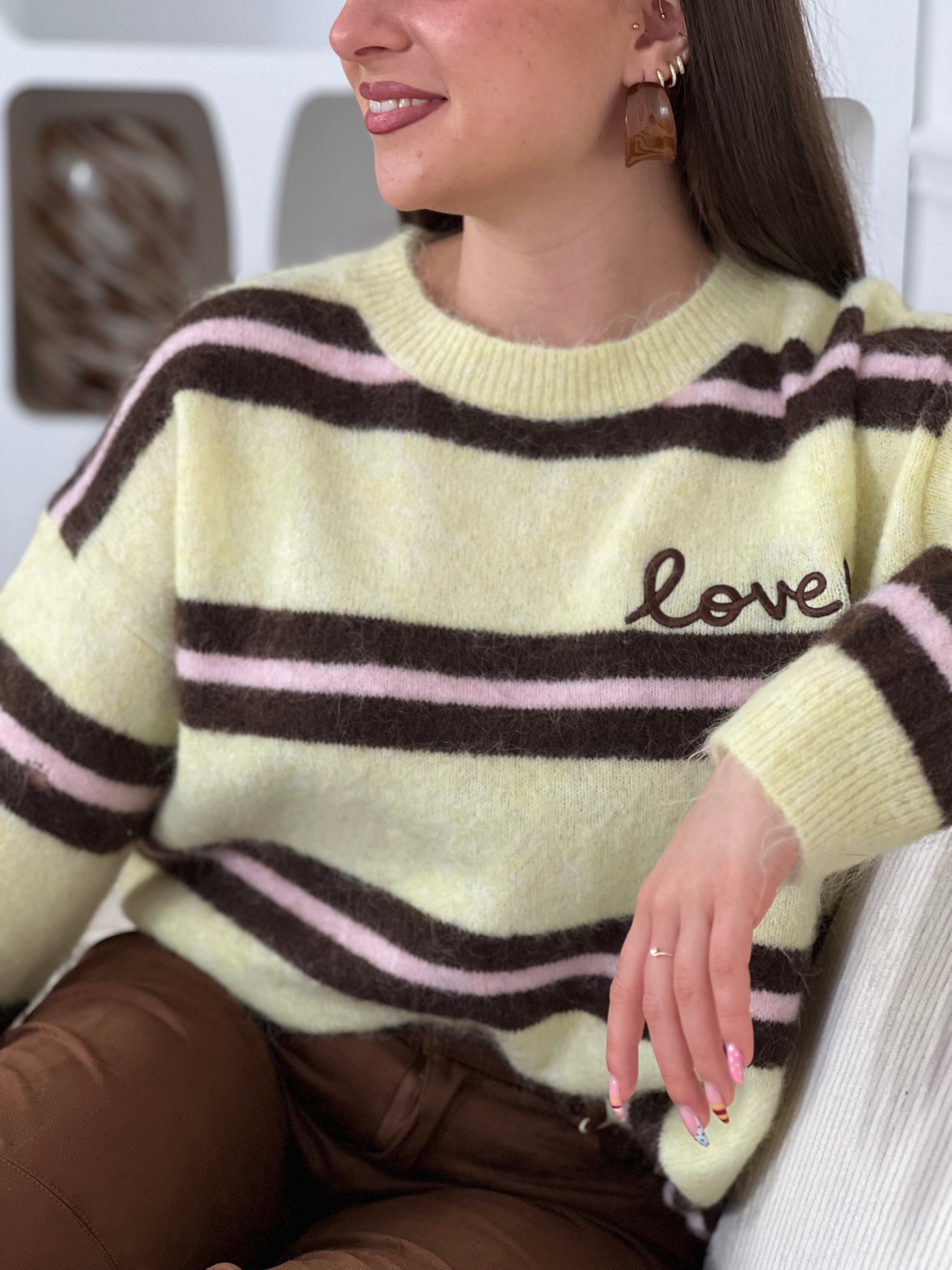Un incontournable de votre garde-robe automne-hiver. Ce pull femme en laine allie confort et style avec ses manches longues et son col rond épuré. Les rayures horizontales marron et roses créent une harmonie visuelle intemporelle, tandis que l'inscription "Love" ornée d'un cœur marron ajoute une touche de tendresse au devant.