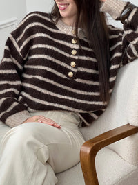 Le pull Maelion allie style et confort avec ses rayures horizontales marron et beige. Manches longues, col rond et boutons dorés sur le devant pour une allure sophistiquée. Une pièce polyvalente qui s'adapte à tous vos looks.
