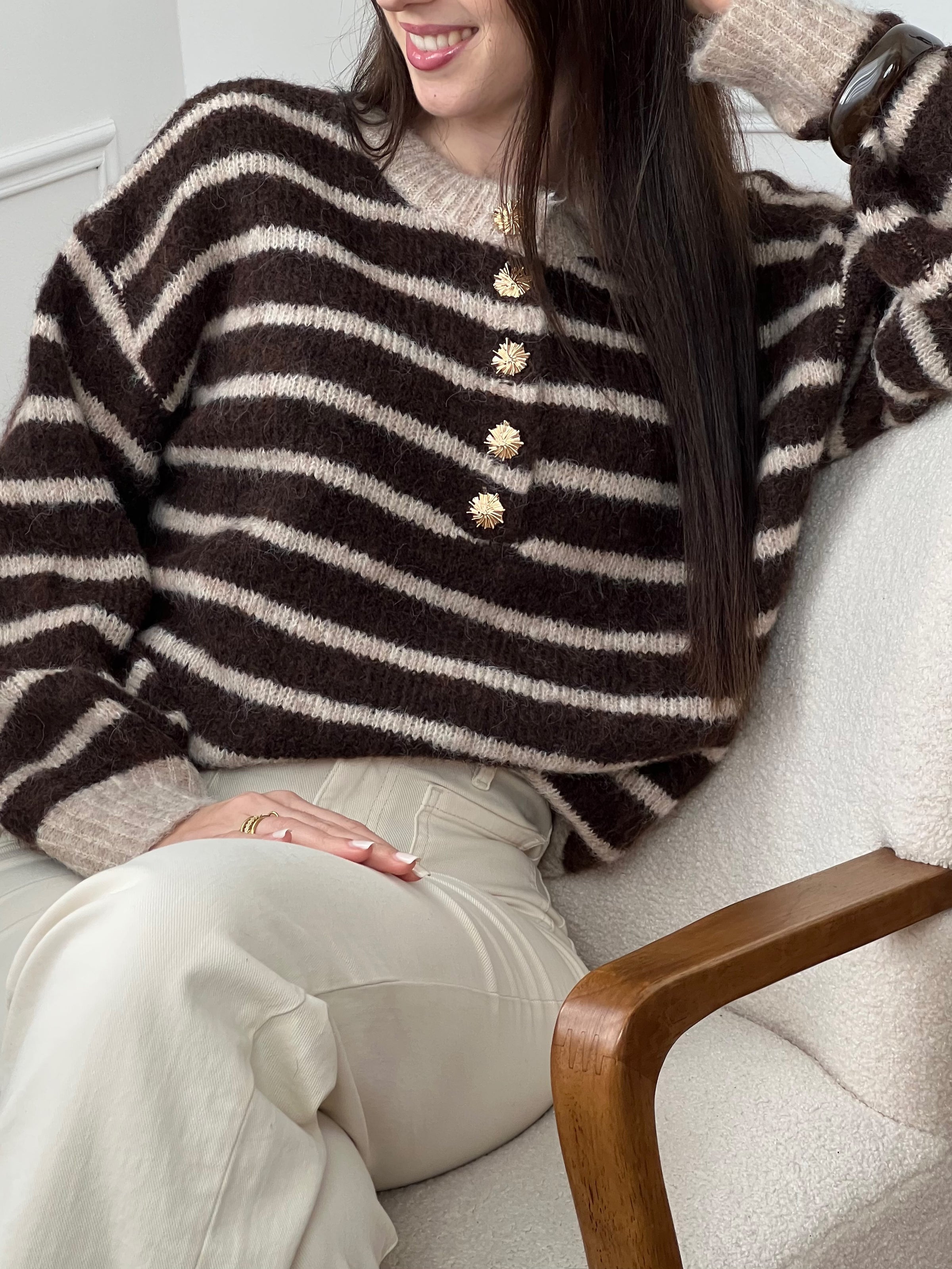Le pull Maelion allie style et confort avec ses rayures horizontales marron et beige. Manches longues, col rond et boutons dorés sur le devant pour une allure sophistiquée. Une pièce polyvalente qui s'adapte à tous vos looks.