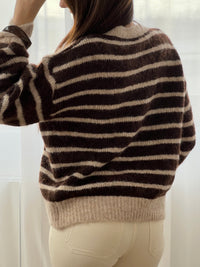 Le pull Maelion allie style et confort avec ses rayures horizontales marron et beige. Manches longues, col rond et boutons dorés sur le devant pour une allure sophistiquée. Une pièce polyvalente qui s'adapte à tous vos looks.