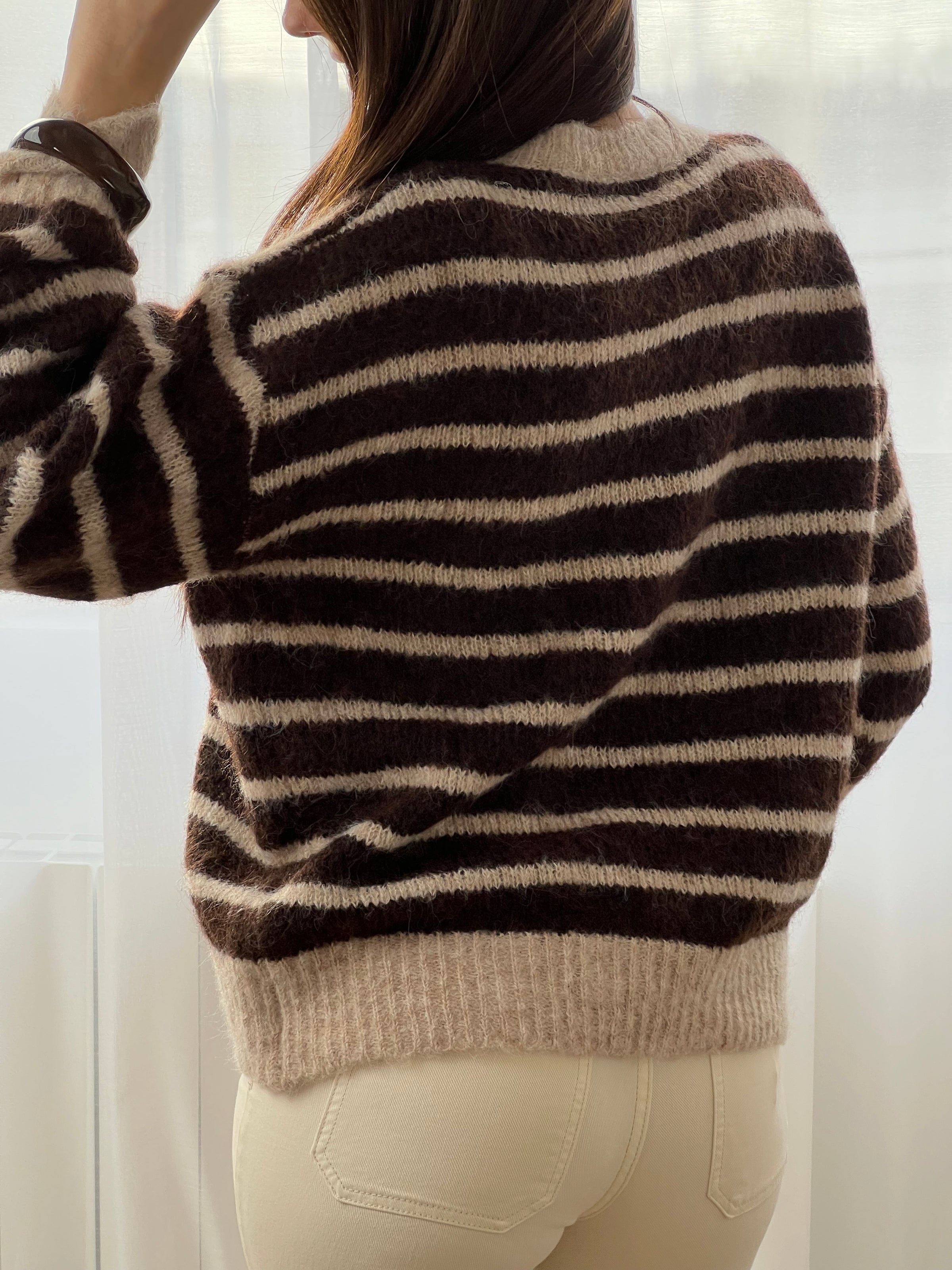 Le pull Maelion allie style et confort avec ses rayures horizontales marron et beige. Manches longues, col rond et boutons dorés sur le devant pour une allure sophistiquée. Une pièce polyvalente qui s'adapte à tous vos looks.
