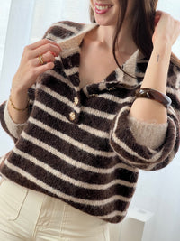 Le pull Maelion allie style et confort avec ses rayures horizontales marron et beige. Manches longues, col rond et boutons dorés sur le devant pour une allure sophistiquée. Une pièce polyvalente qui s'adapte à tous vos looks.