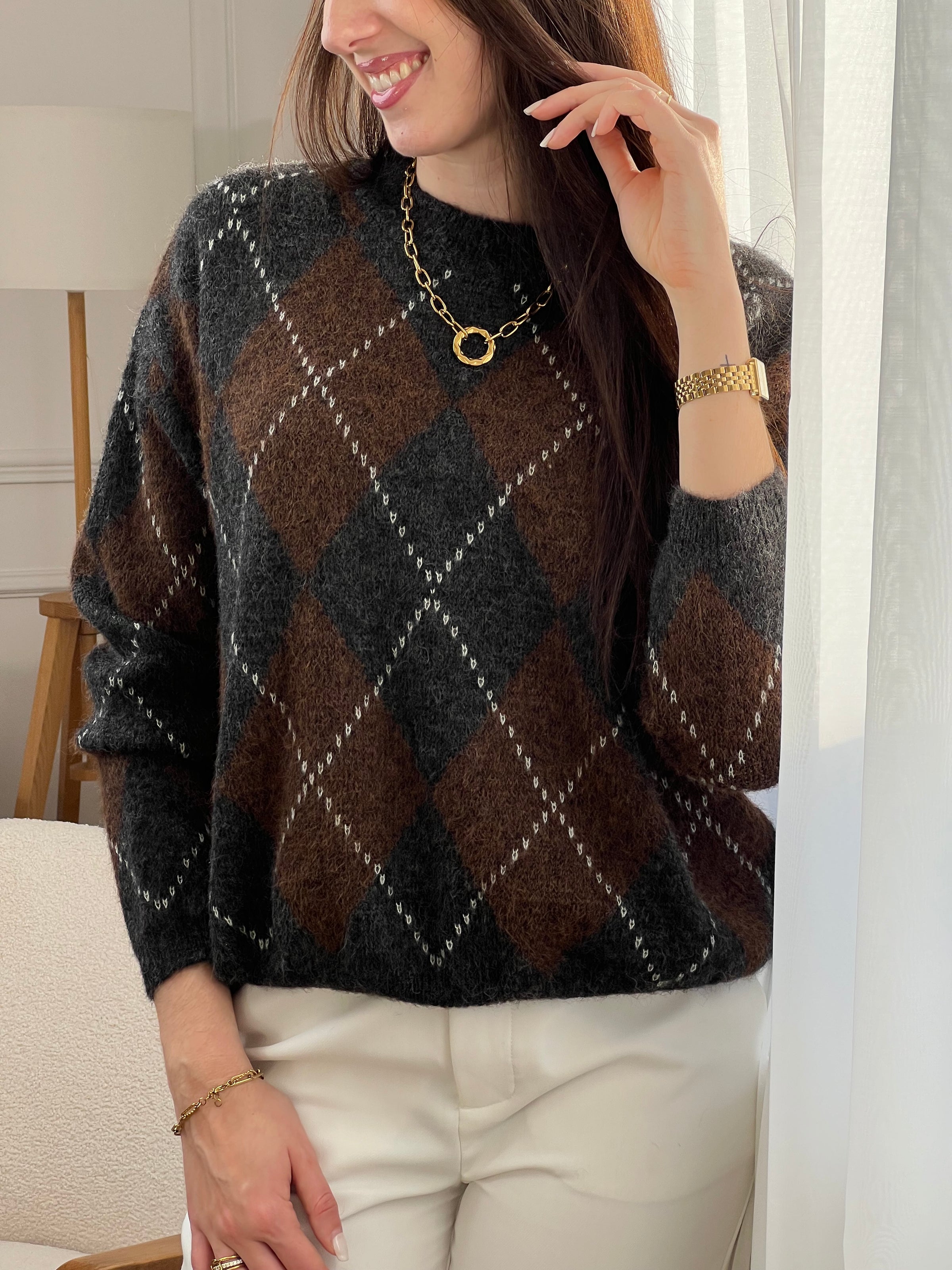 Pull femme Solea aux motifs losanges géométriques. Manches longues et col rond pour un style intemporel. Teintes harmonieuses de marron, écru et gris foncé qui s'associent facilement à vos tenues du quotidien.